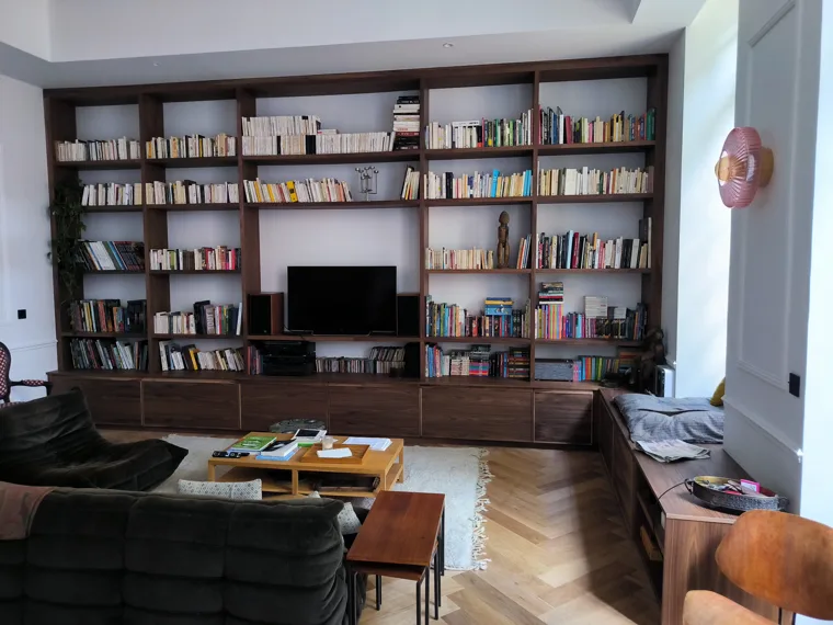 Bibliothèque murale avec rangements bas et espace pour le téléviseur.