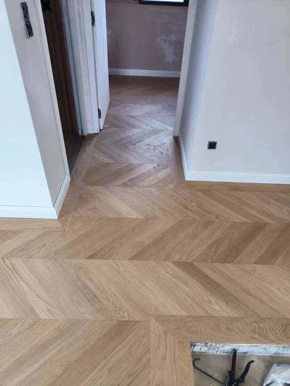 Parquet à motifs en chevrons dans un dégagement.