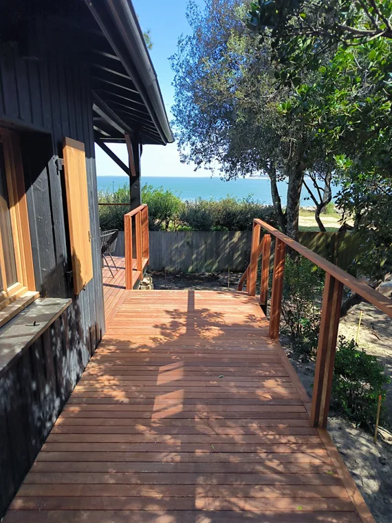 Terrasse en bois avec garde-corps donnant sur le jardin.